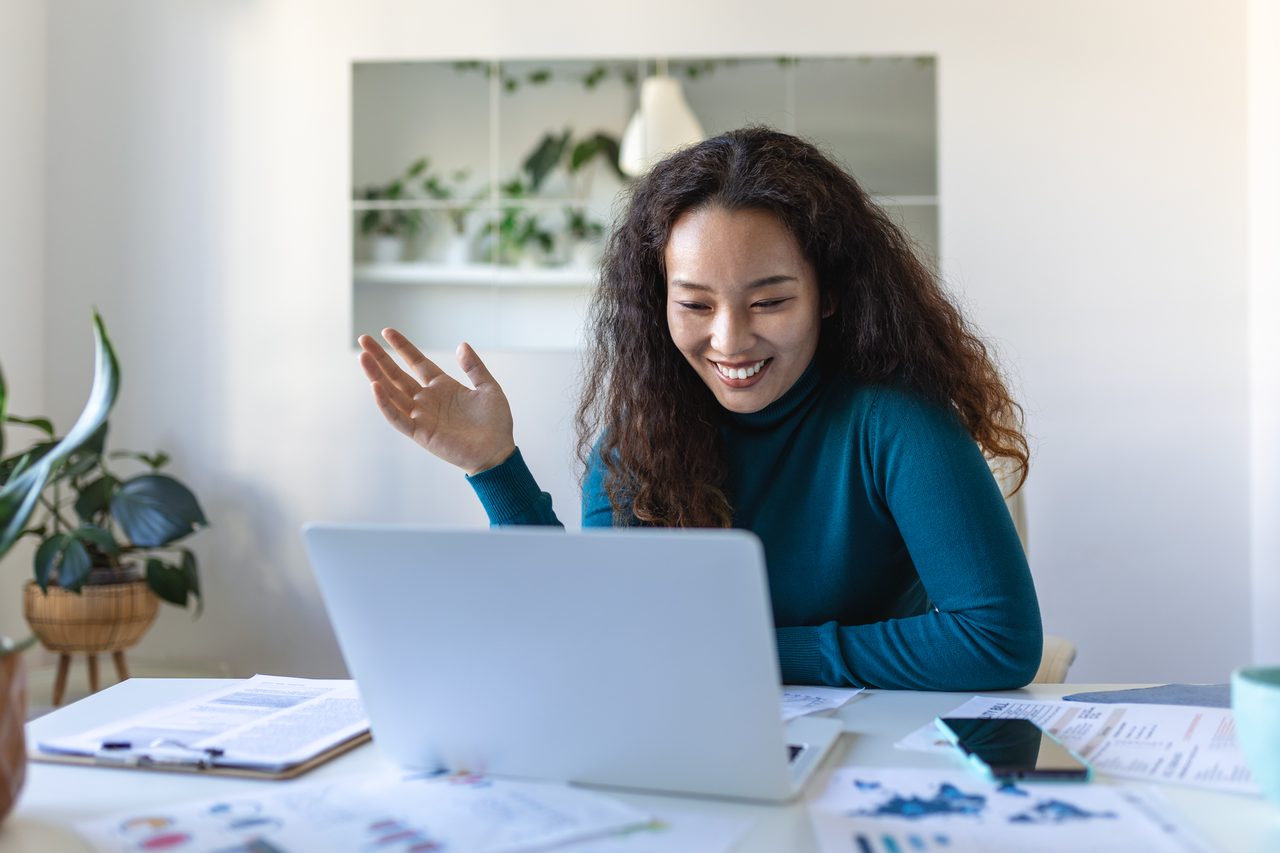 Financial professional smiling during a video consultation on a laptop
