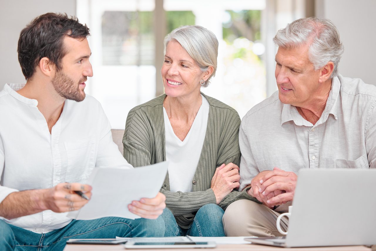 Financial advisor reviewing retirement documents with a senior couple at home
